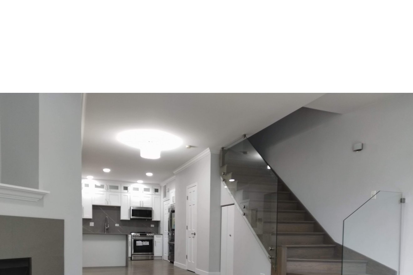 Andar principal depois — escada com guarda-corpo de vidro e cozinha shaker branca
